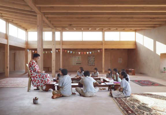 Lehrerin und Schüler im Innenraum mit der Ladakh Minimum School in Indien.