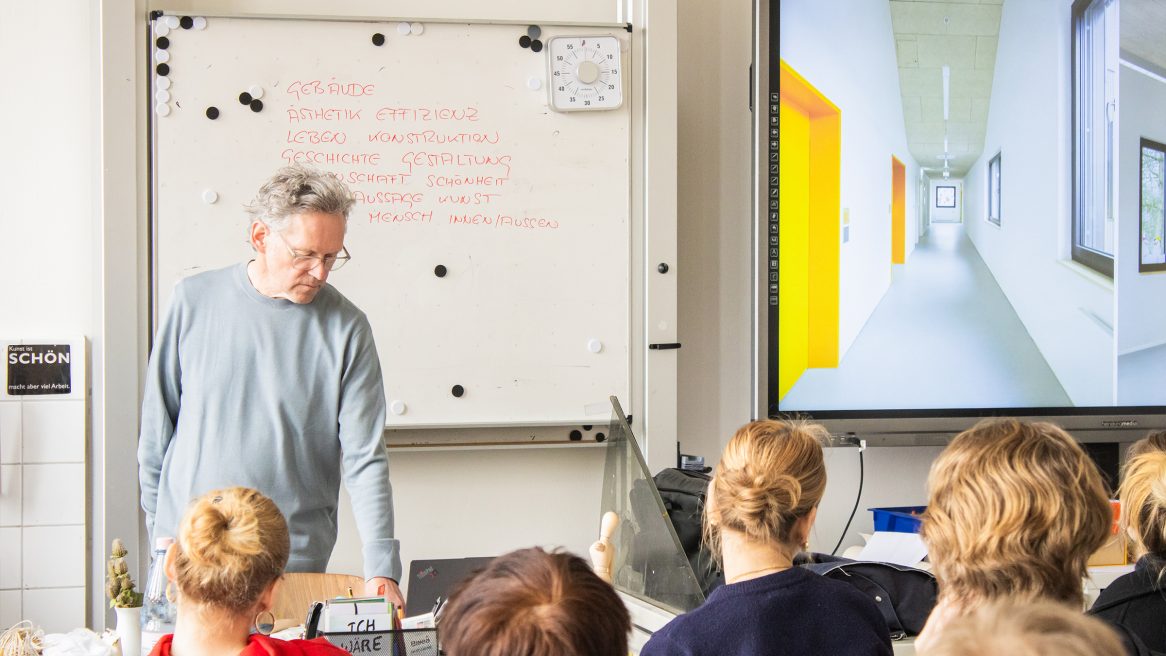 Prof. Xaver Egger mit Schülern im Klassenzimmer.