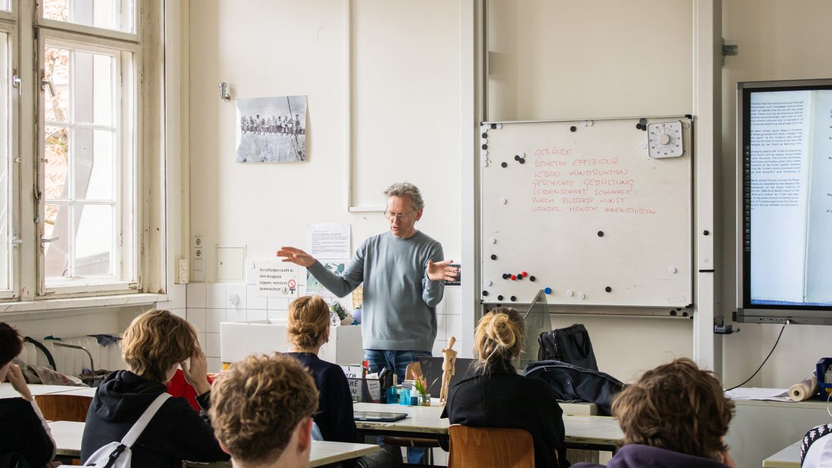 Prof. Xaver Egger mit Schülern im Klassenzimmer.