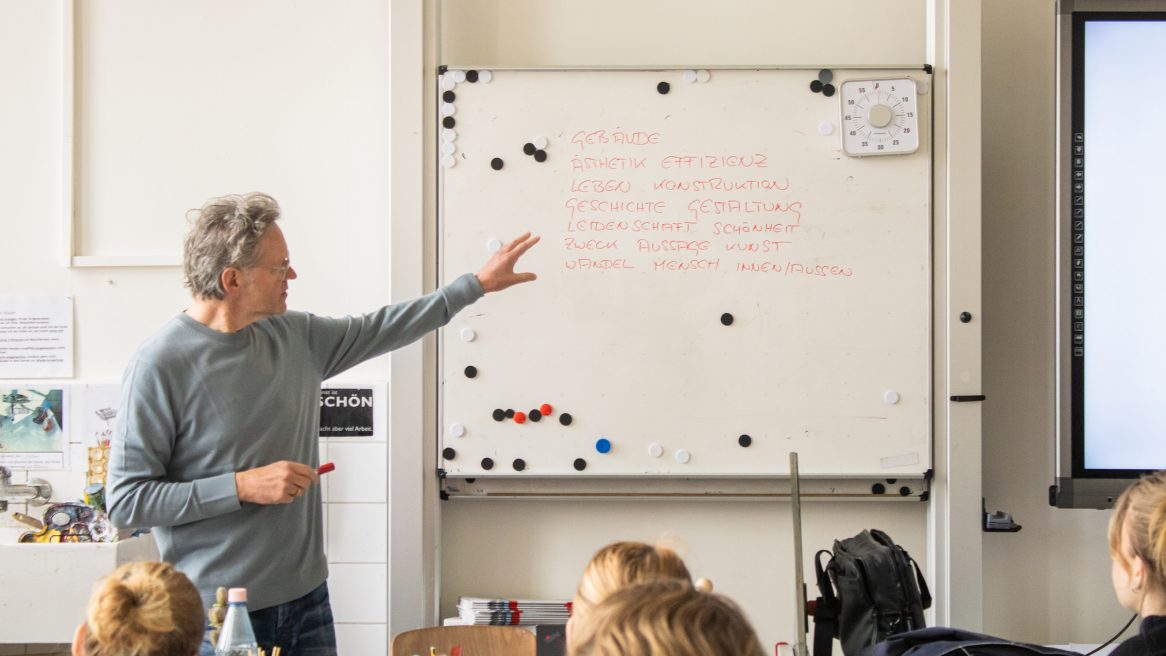 Prof. Xaver Egger mit Schülern im Klassenzimmer.