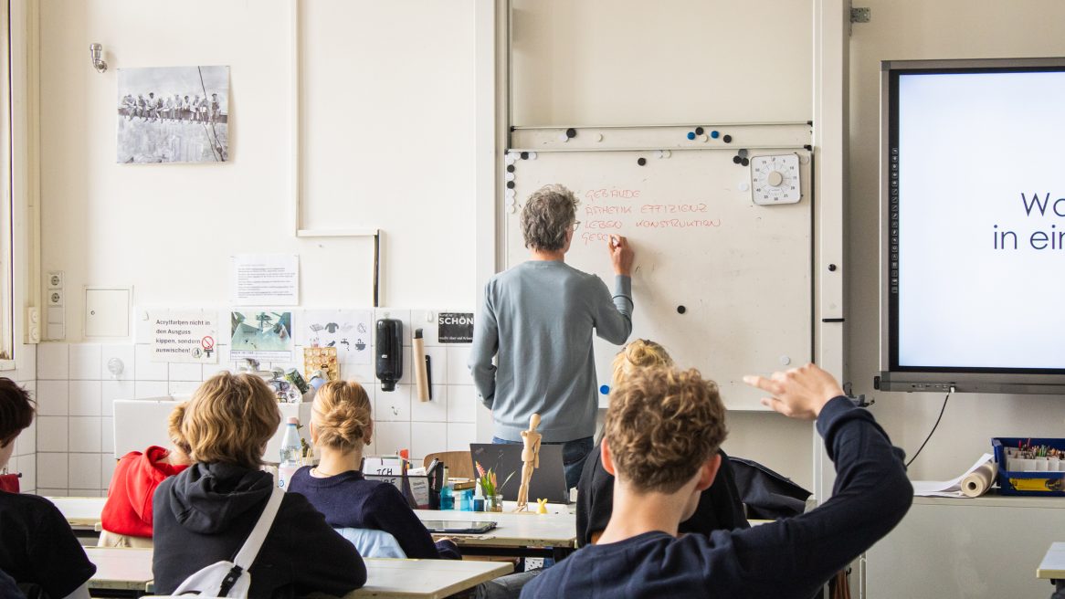 Prof. Xaver Egger mit Schülern im Klassenzimmer.
