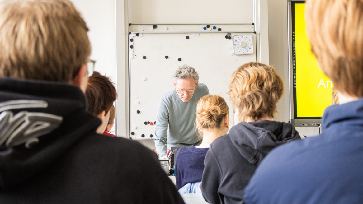 Prof. Xaver Egger mit Schülern im Klassenzimmer.