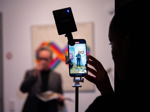 Prof. Xaver Egger während seines Vortrags, gefilmt mit einem Smartphone.