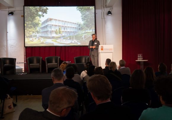 Prof. Xaver Egger auf der Bühne bei der Schulbaumesse 2023 in Berlin.