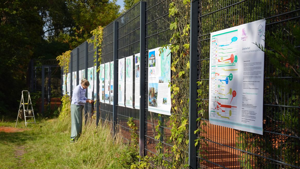 Besucher*innen betrachten die Plakate des Masterplans Buch bei der Präsentation im Panke-Park-Fest in Berlin-Buch.
